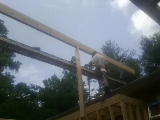 Carpenter setting a ridge beam over a new addition frame — Ice Dam Removal by Roofing Brothers in Inglis