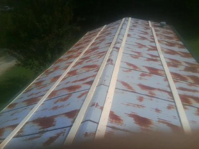 Rusted metal roof panels with new wood purlins before replacement — Storm Damage Roof Repair in Inglis by Roofing Brothers