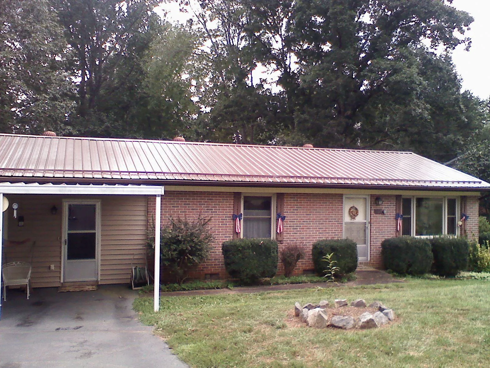 Bronze metal roof and carport on a brick ranch home — Roof Repair work by our crew in Inglis